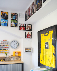 An der Wand hängende Erinnerungsfotos mit Fußballprofis und ein Trikot
