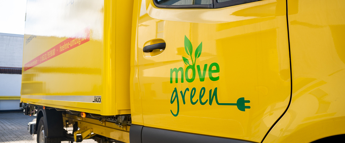 Gelber Umzugs-LKW mit dem "Move Green"-Logo