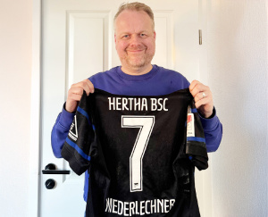 Ralf Feller (Mitglied der Geschäftsleitung von Höhne-Grass) mit dem Trikot von Florian Niederlechner 