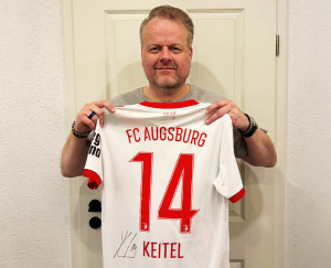 Ralf Feller aus der Geschäftsleitung mit dem signierten Trikot von Yannik Keitel 