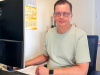 Der langjährige Höhne-Grass Kollege Jens Mikoteit sitzt lächelnd an seinem Schreibtisch im Büro des Umzugsunternehmens.
